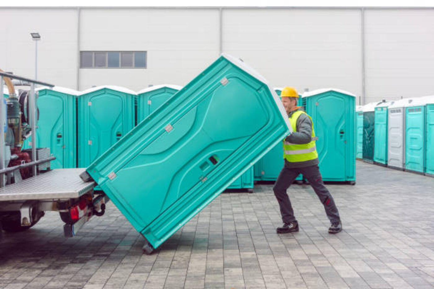 Septic pumping truck servicing a portable toilet on site